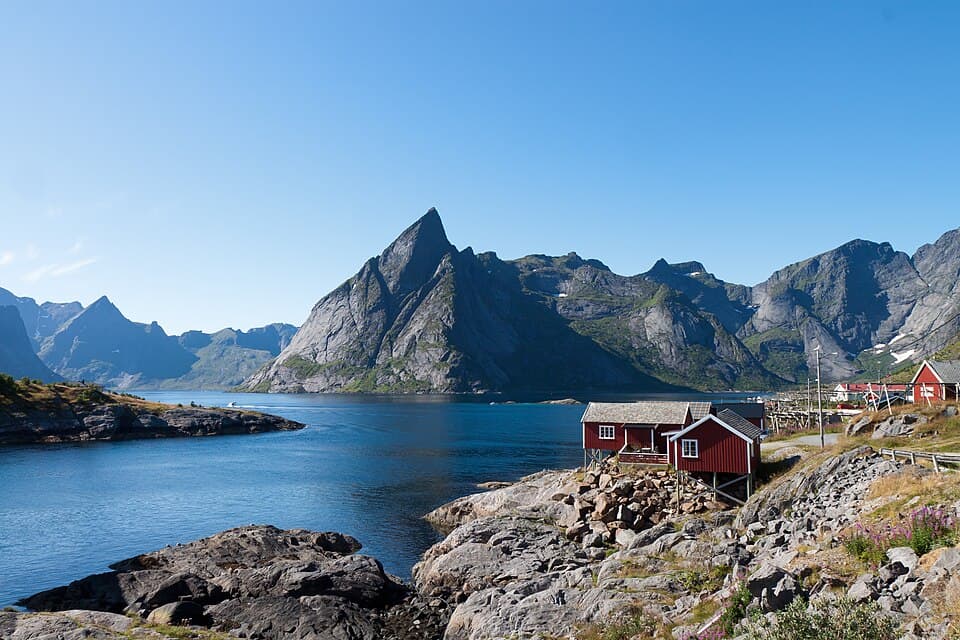 Stilted rorbuer over the water at Hamnøya in golden light, Reinefjorden, Lofoten