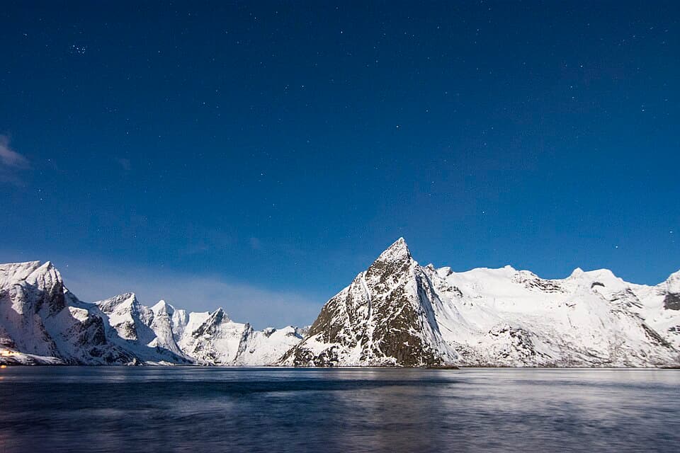 Classic red rorbu cabins at Hamnøy with snow-capped peaks behind, Lofoten
