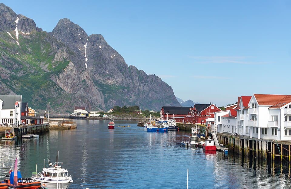 The fishing village of Henningsvær in summer with blue sky and mountains, Lofoten